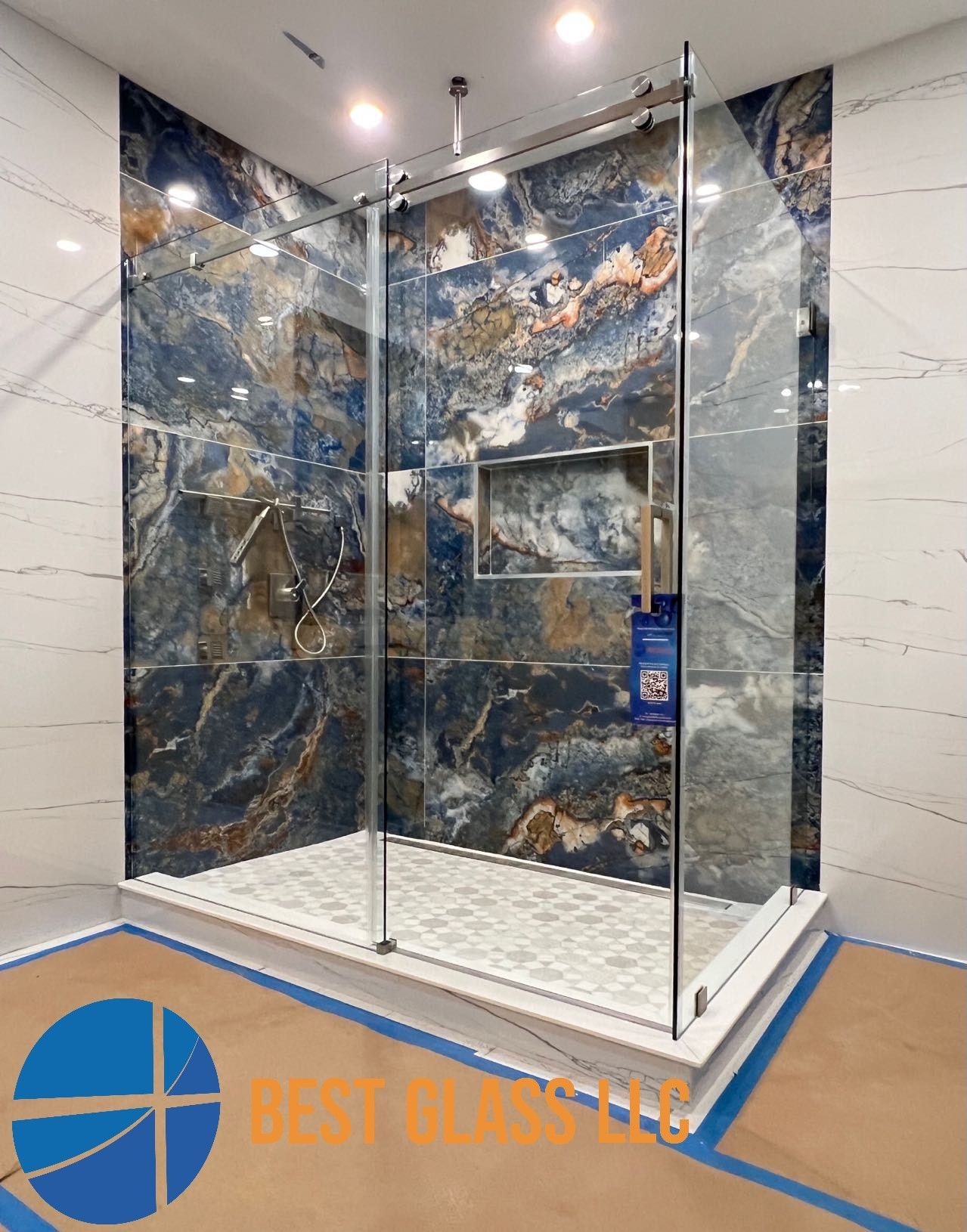 A bathroom with a walk in shower and marble walls.