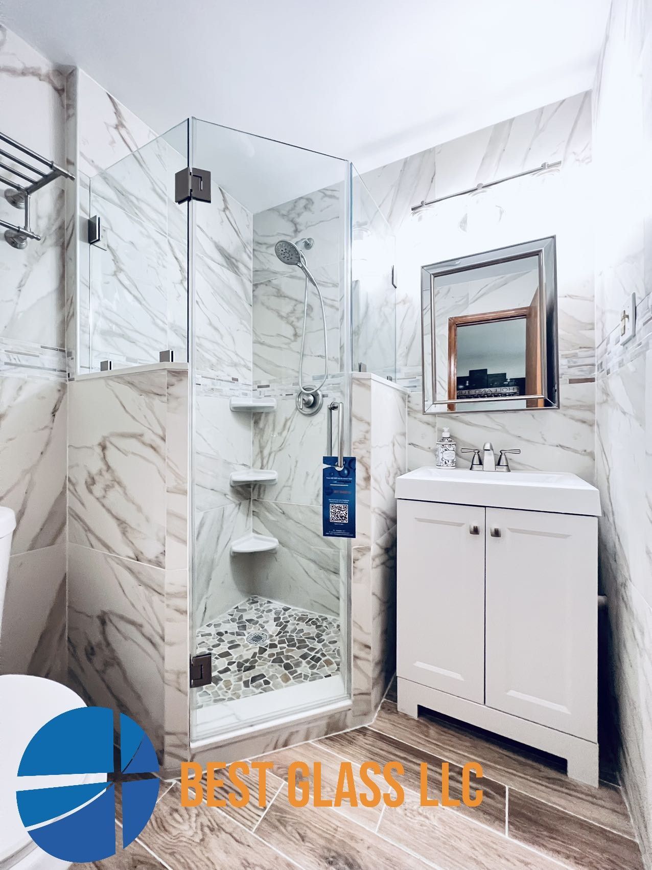 A bathroom with a walk in shower , sink and mirror.