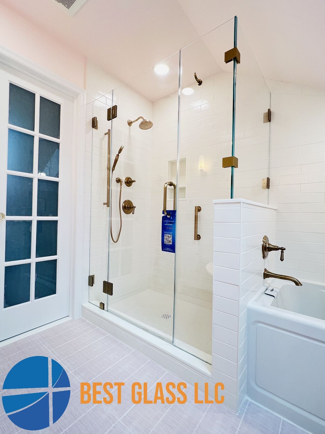 A bathroom with a glass shower door and a bathtub