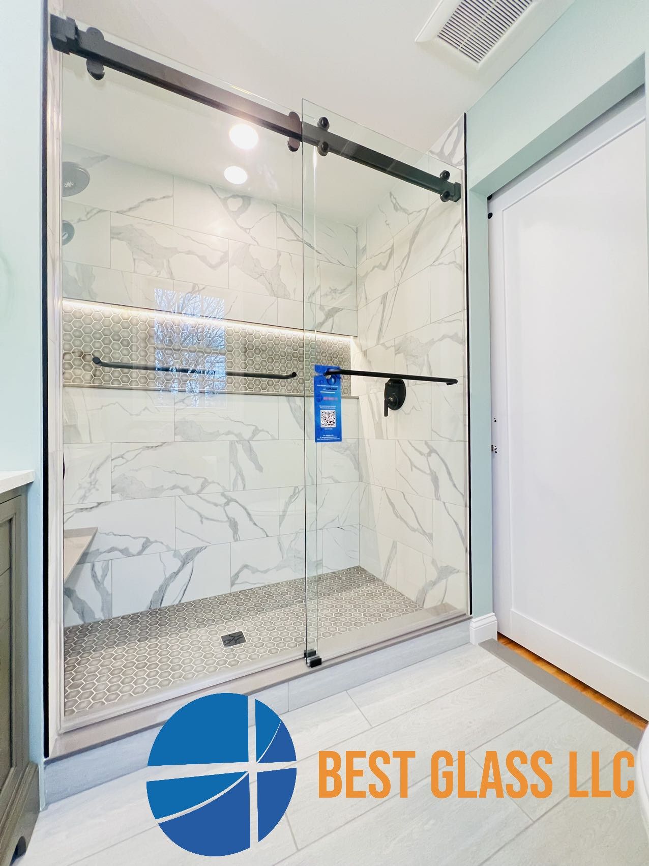A bathroom with a sliding glass shower door.