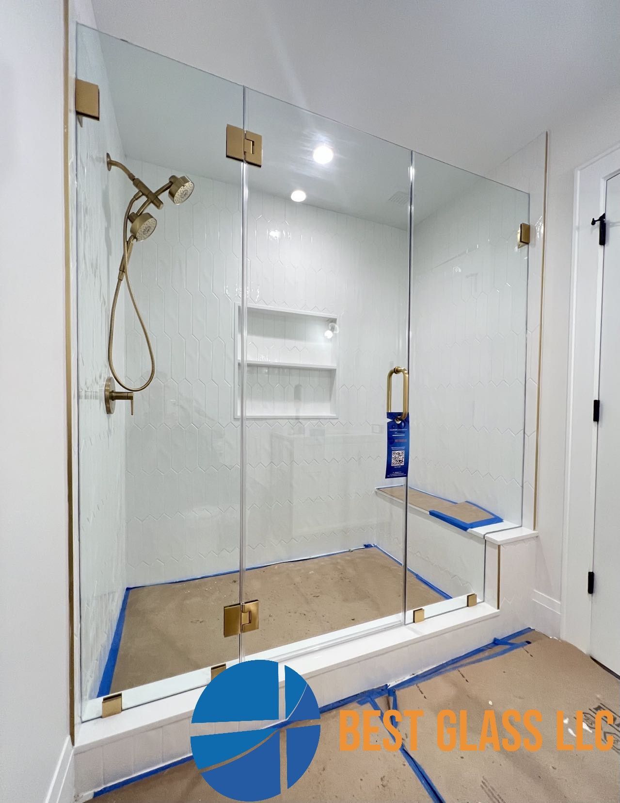 A bathroom with a glass shower door and a shower head.