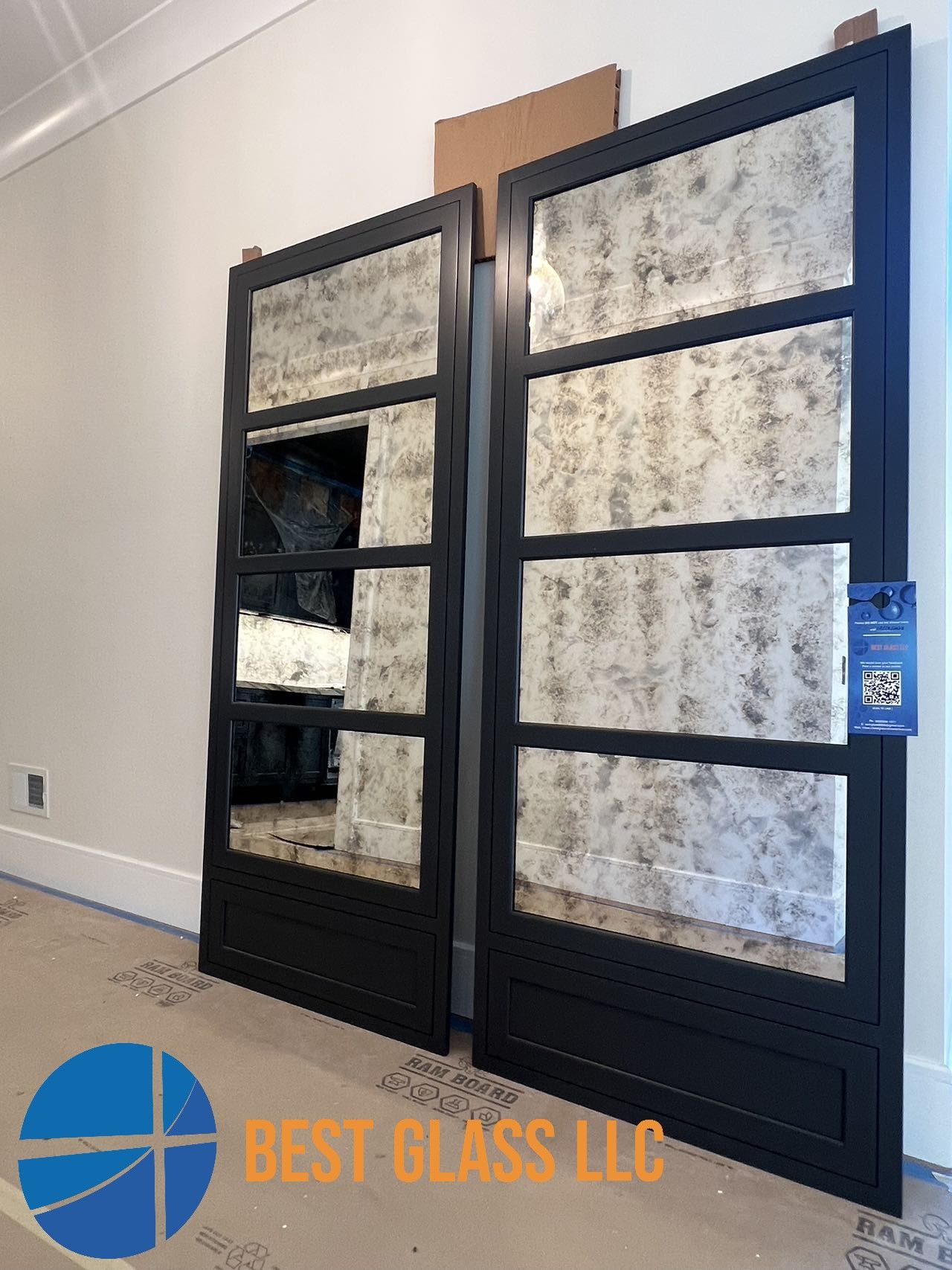 A pair of black doors with mirrors on them are sitting next to each other in a room.