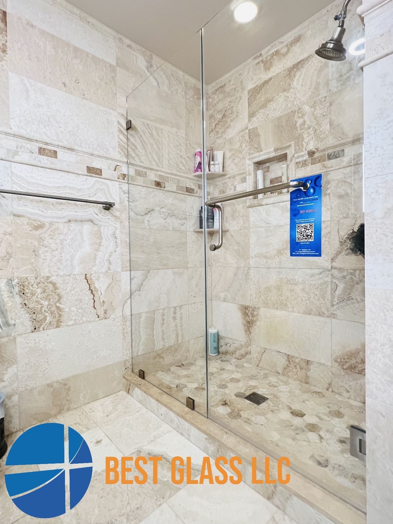 A bathroom with a walk in shower and a sign that says best glass llc