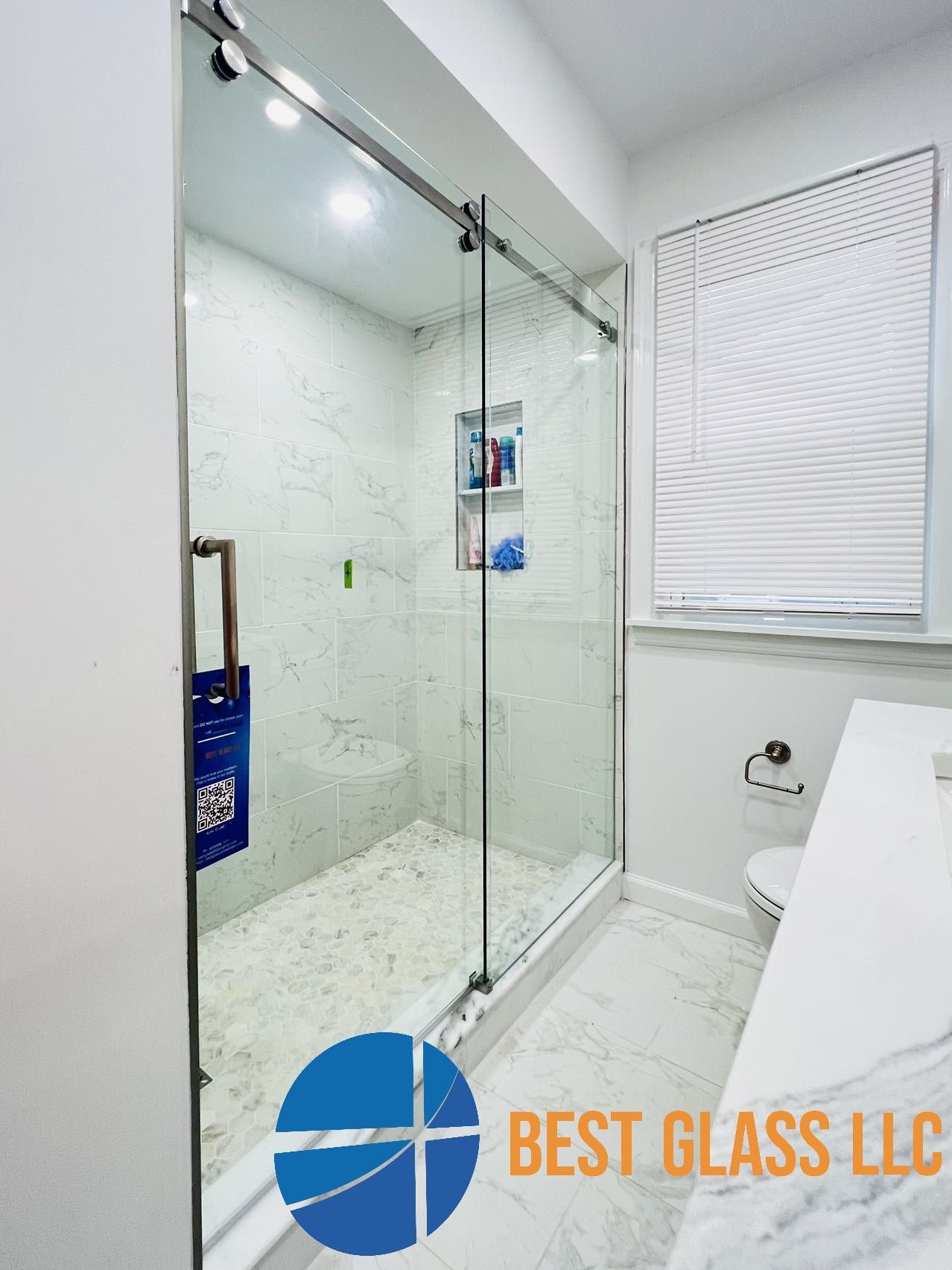 A bathroom with a sliding glass shower door from best glass llc