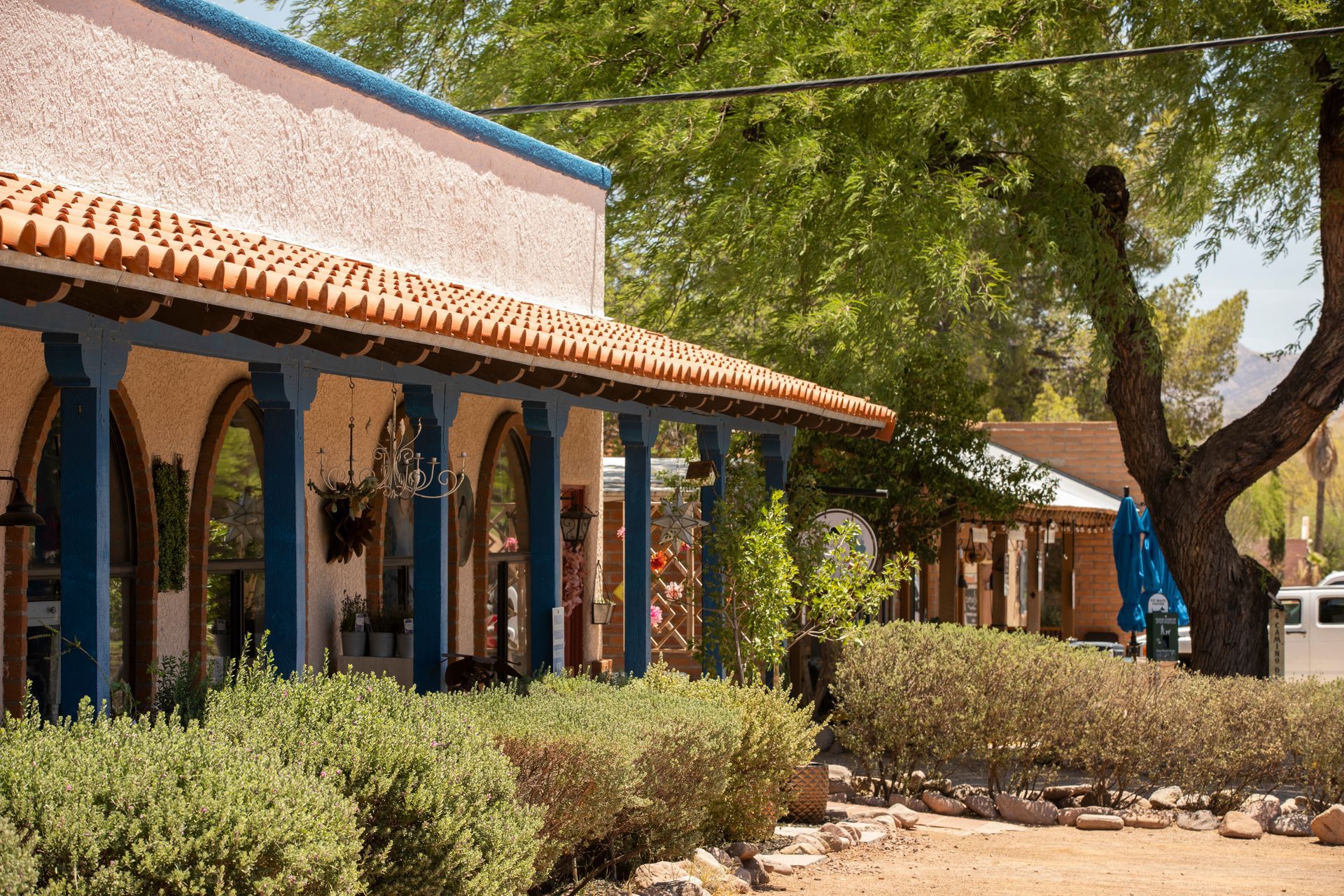 A building with a porch and a tree in front of it.