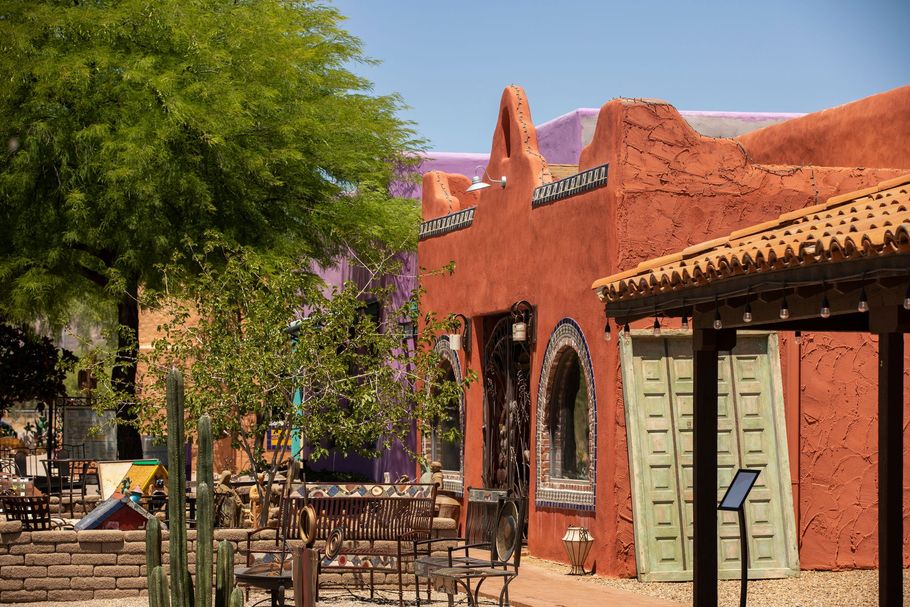 A red building with a purple roof and a cactus in front of it.