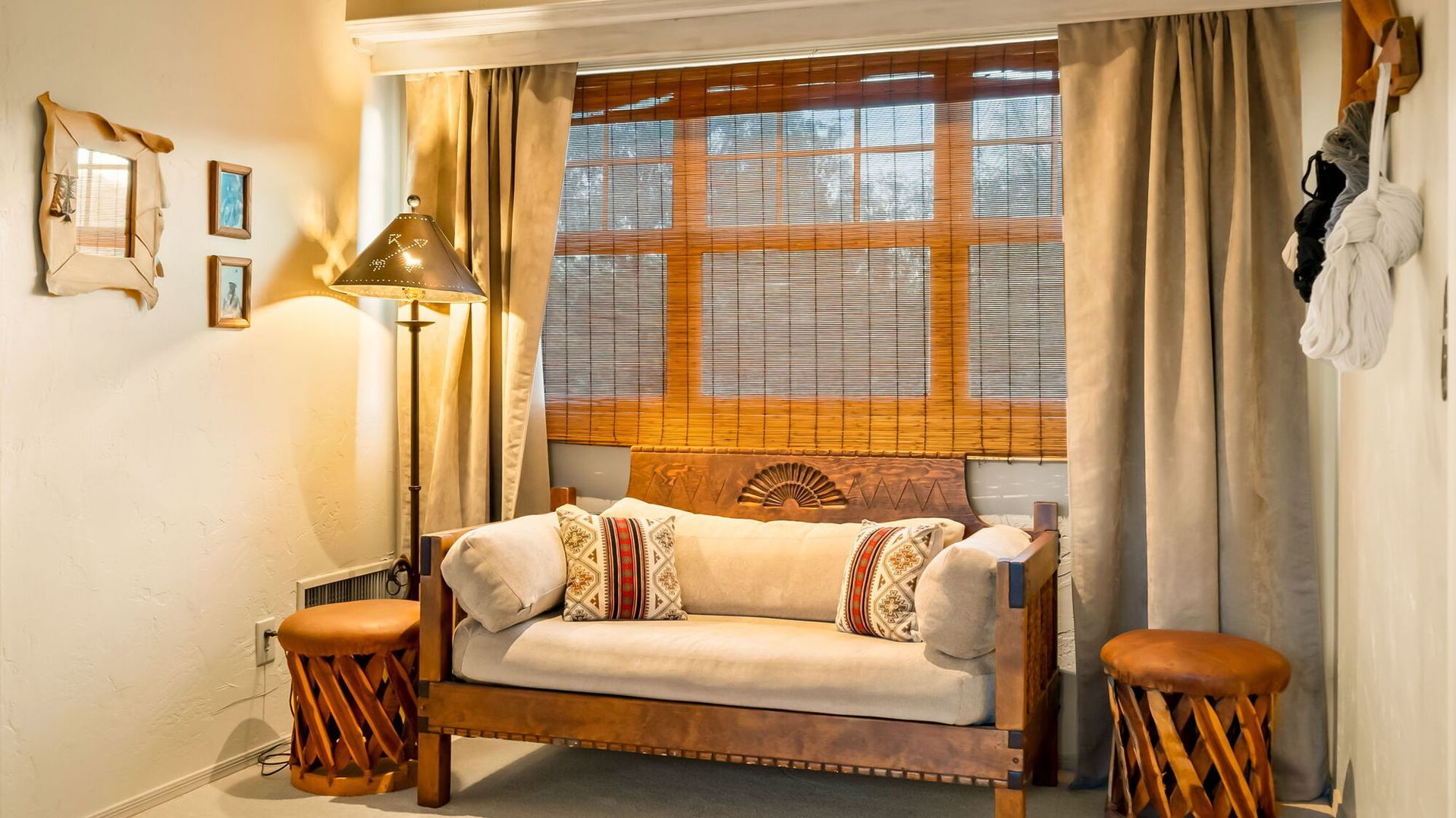 A living room with a couch and two stools in front of a window.