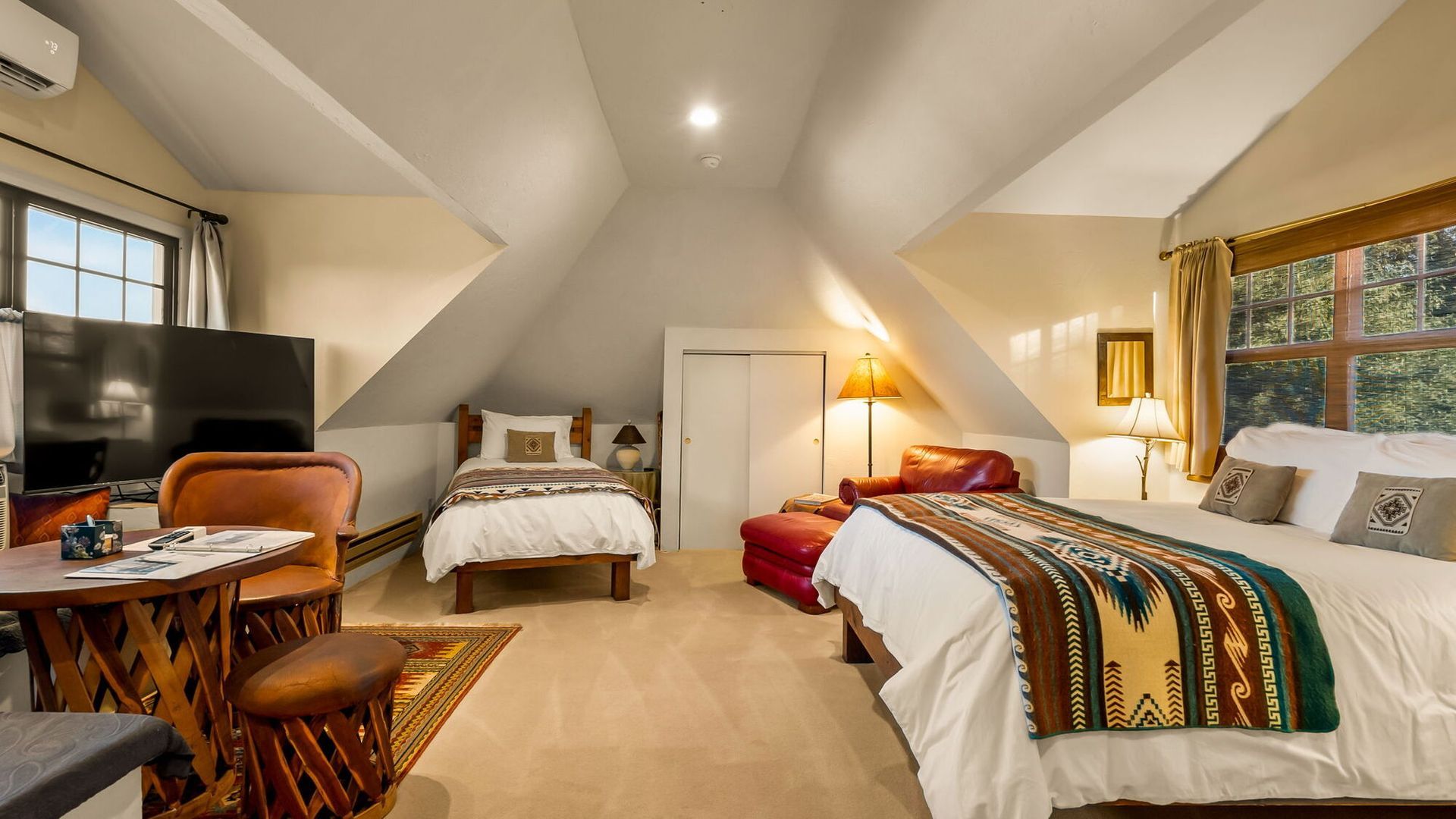 A bedroom with two beds , a table and a television.