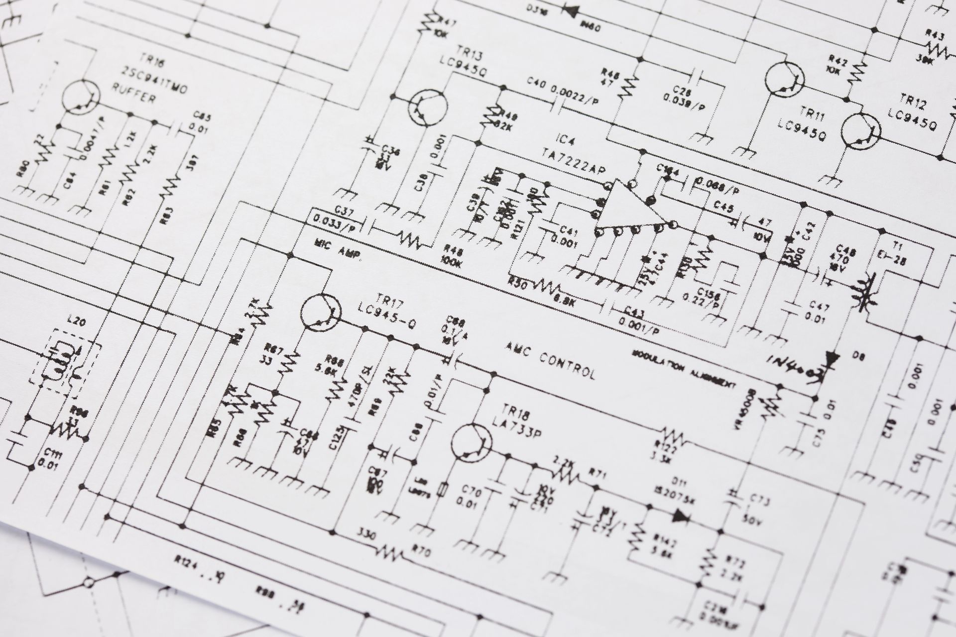 Primo piano di uno schema di circuito elettronico stampato, che mostra vari componenti e collegamenti con etichette.