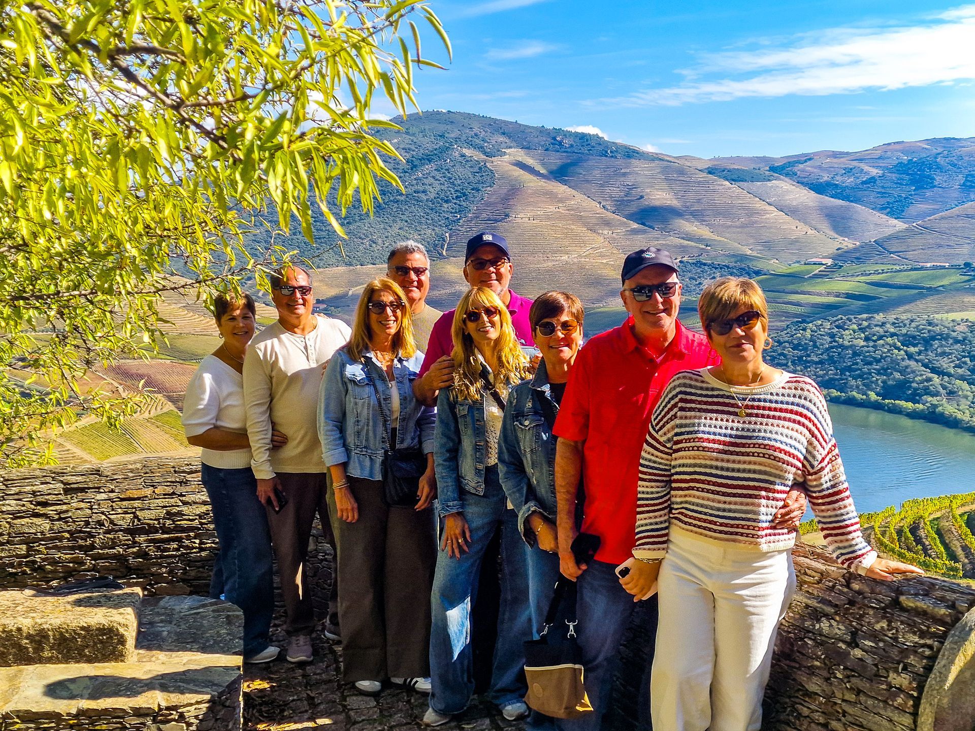 Happy friends stoping in Douro Valley for a visit and a wine tasting during a transfer from Lisbon to Porto with Duca
