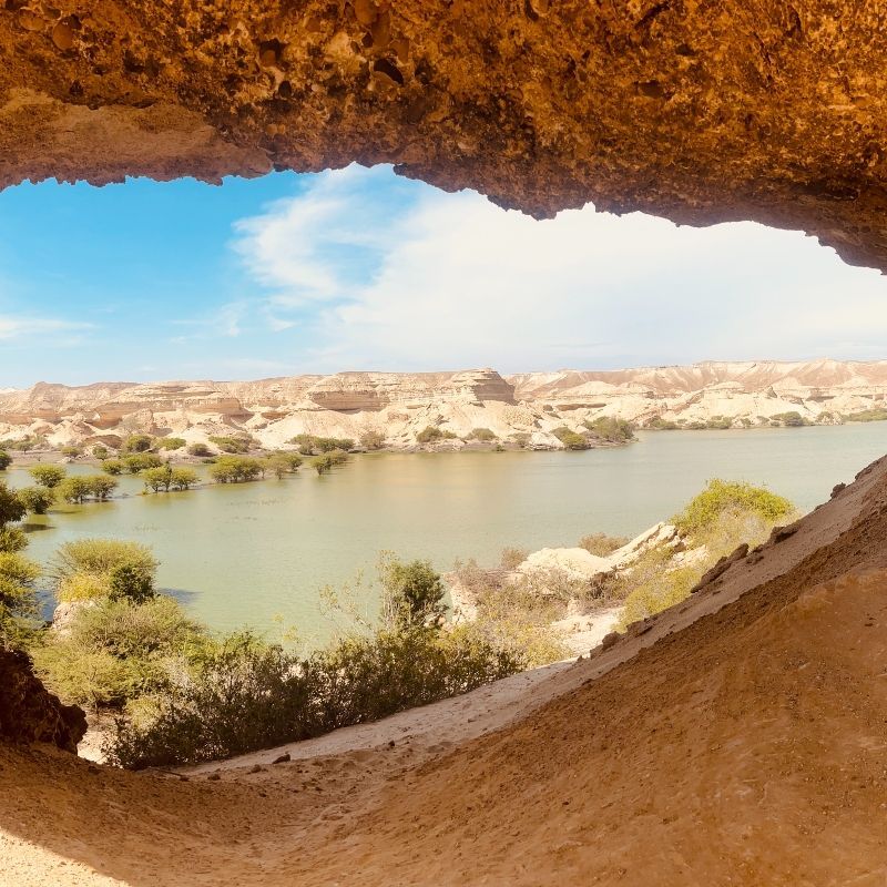 A view of a lake from inside a cave