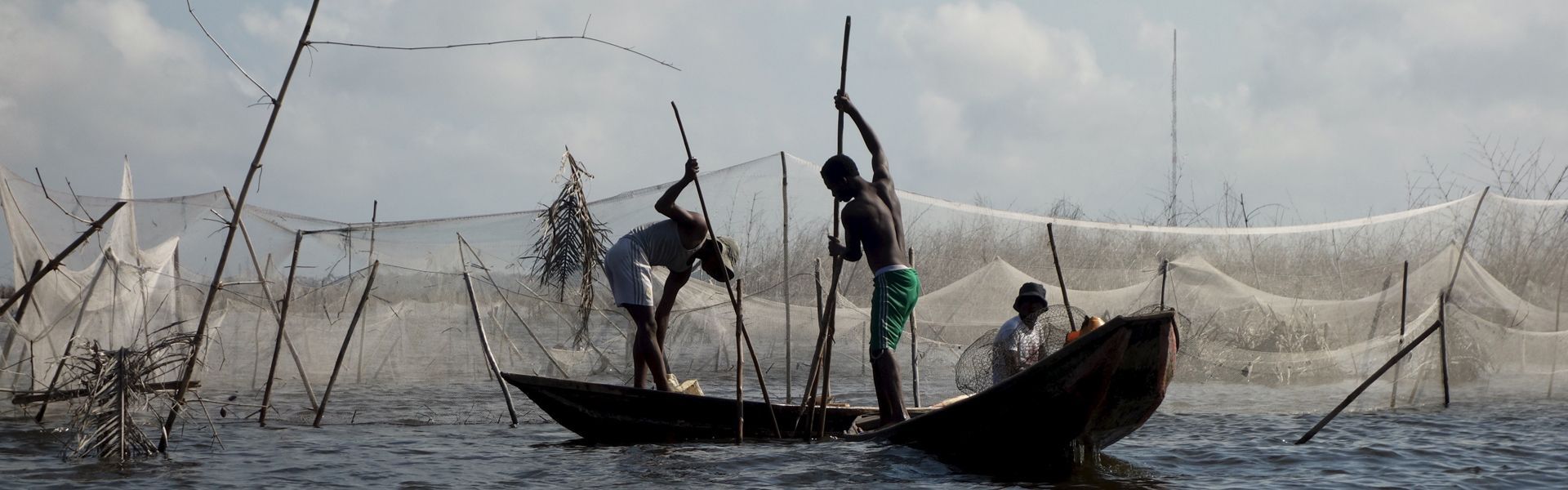 A group of people are fishing in a boat in the water.