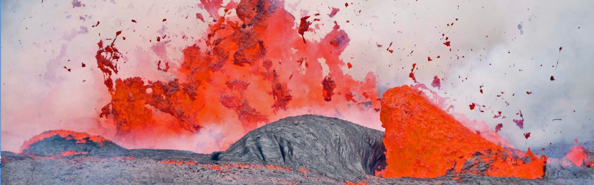 A volcano is erupting with lava coming out of it.