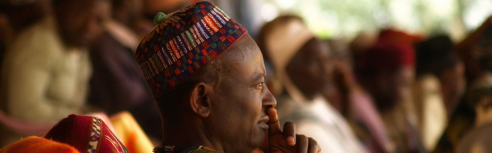 A man is leading a herd of goats across a river.