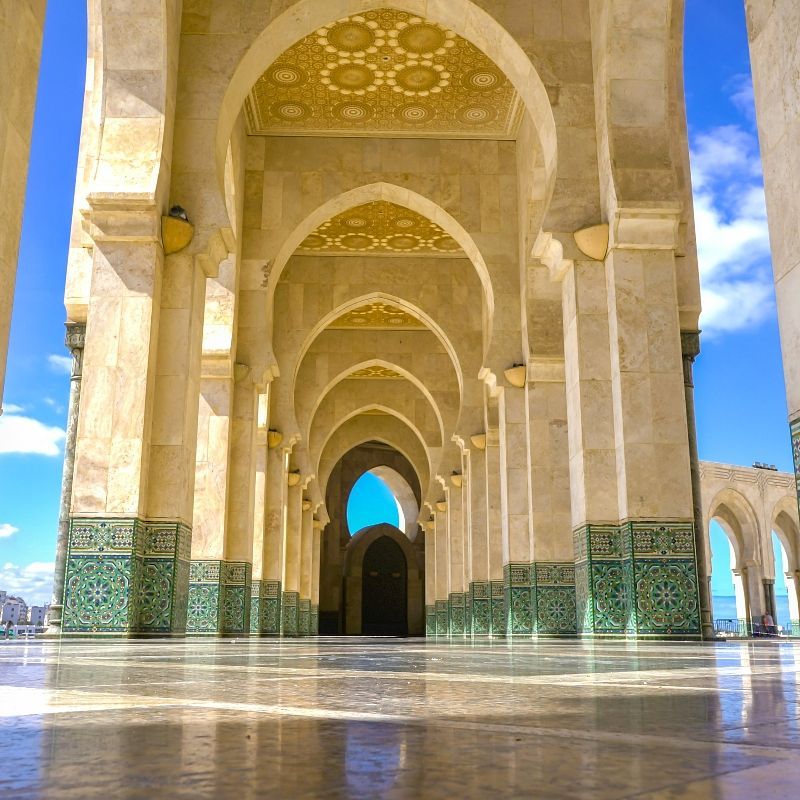 A row of arches in a building with a blue sky in the background