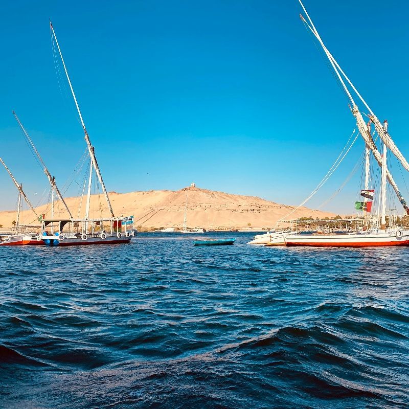 A group of sailboats are floating on top of a large body of water.