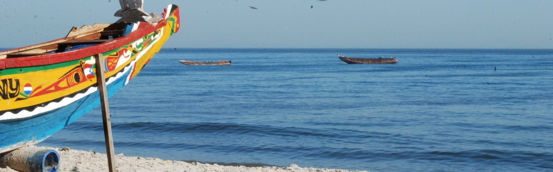 This vibrant image showcases the colorful prow of a traditional fishing boat resting on the sandy beach, facing the vast Atlantic Ocean—an iconic scene along Senegal’s coastline. These beautifully painted boats, known as pirogues, are a symbol of the country’s deep-rooted fishing culture and coastal heritage. From bustling seaside villages to serene beaches, Senegal’s shoreline offers authentic charm and scenic beauty. Discover the coastal traditions and hidden treasures of Senegal with CicoTours, your expert local partner. Africa DMC's, through its network of great locally based tour operators, organizes unforgettable journeys along Senegal’s captivating Atlantic coast.
