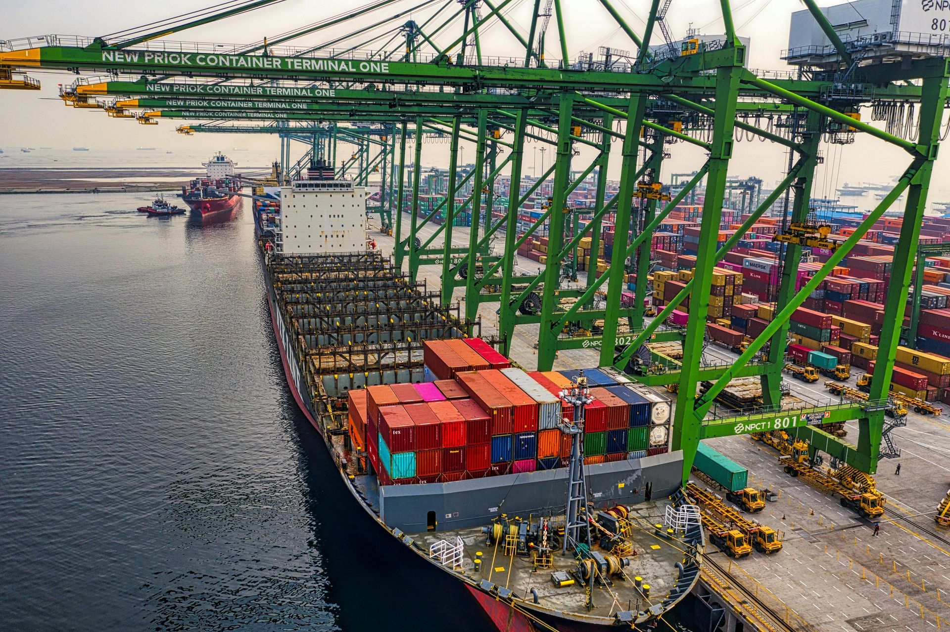 An aerial view of a large container ship docked at a port.