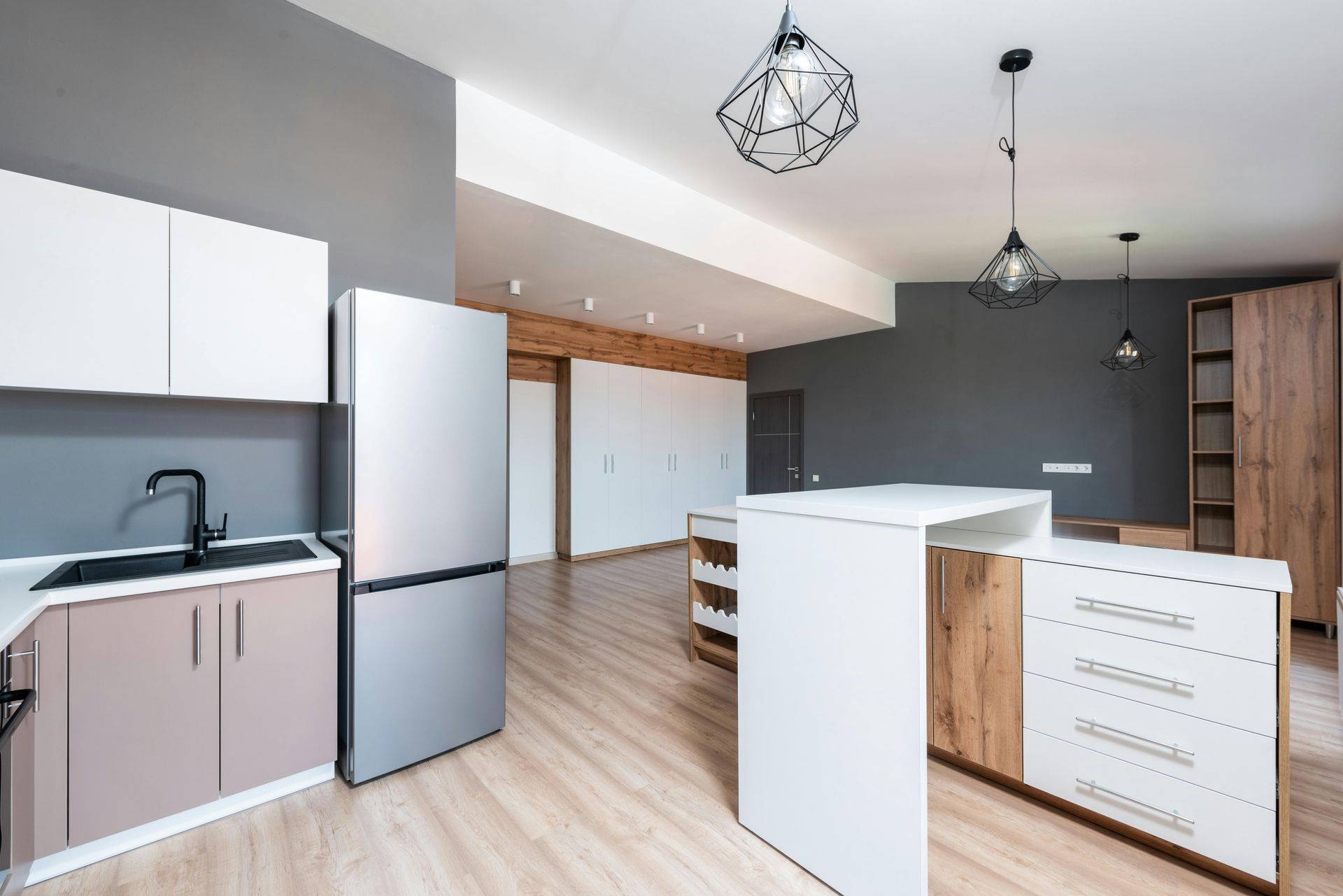 A kitchen with a refrigerator , sink , and cabinets.