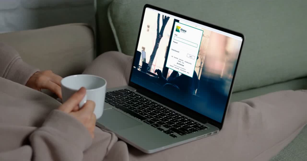A person is sitting on a couch watching a movie on a laptop computer.
