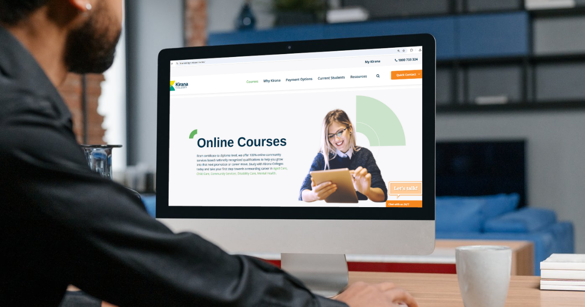 A man is sitting at a desk looking at a computer screen.