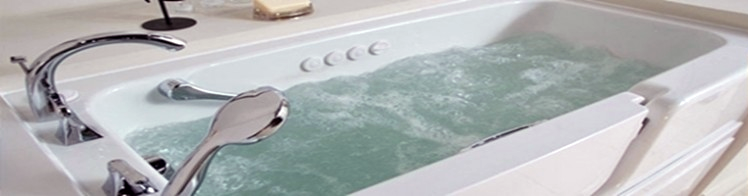 A bathtub filled with water and a shower head in a bathroom.