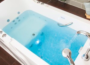 A bathtub filled with blue water in a bathroom.