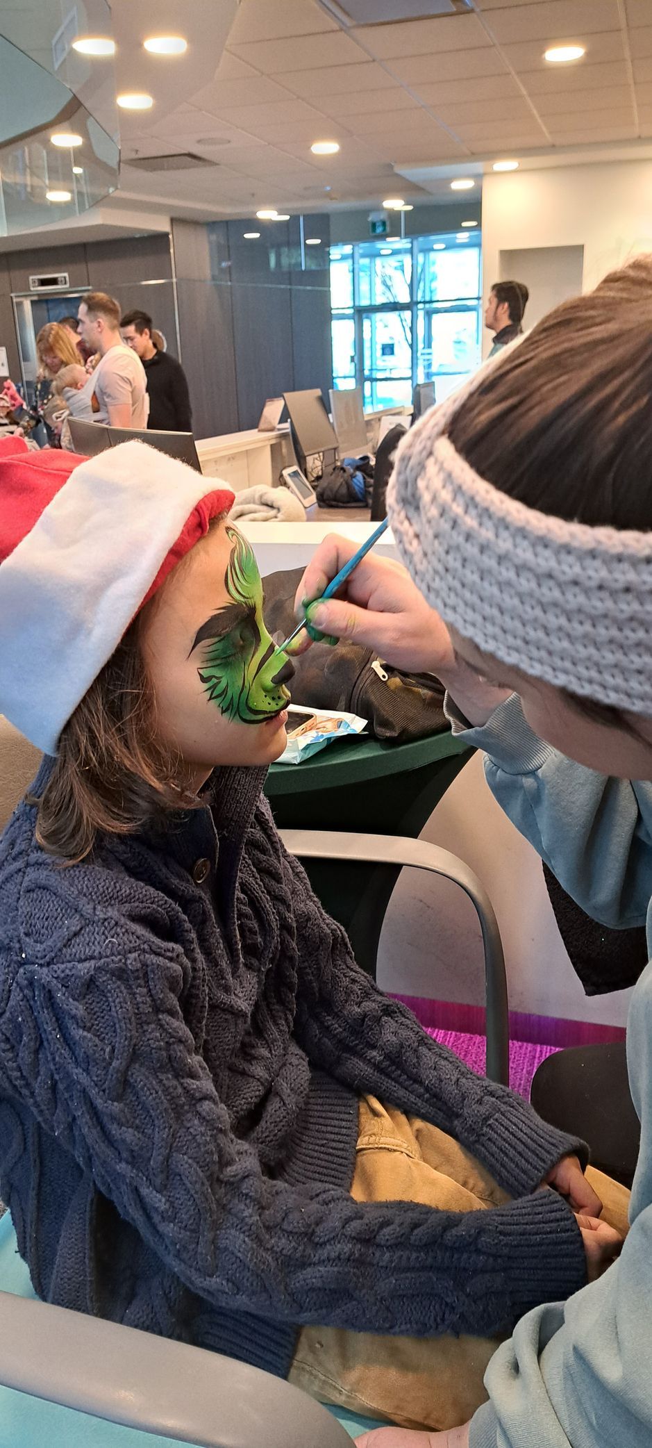 face painter painting child's face at children's corporate holiday party