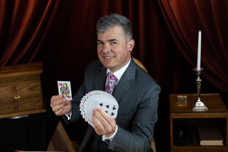 magician holds up cards during live event performance