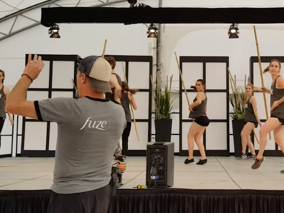 Brian Hansen, wearing a fuze shirt directs a dance number on stage