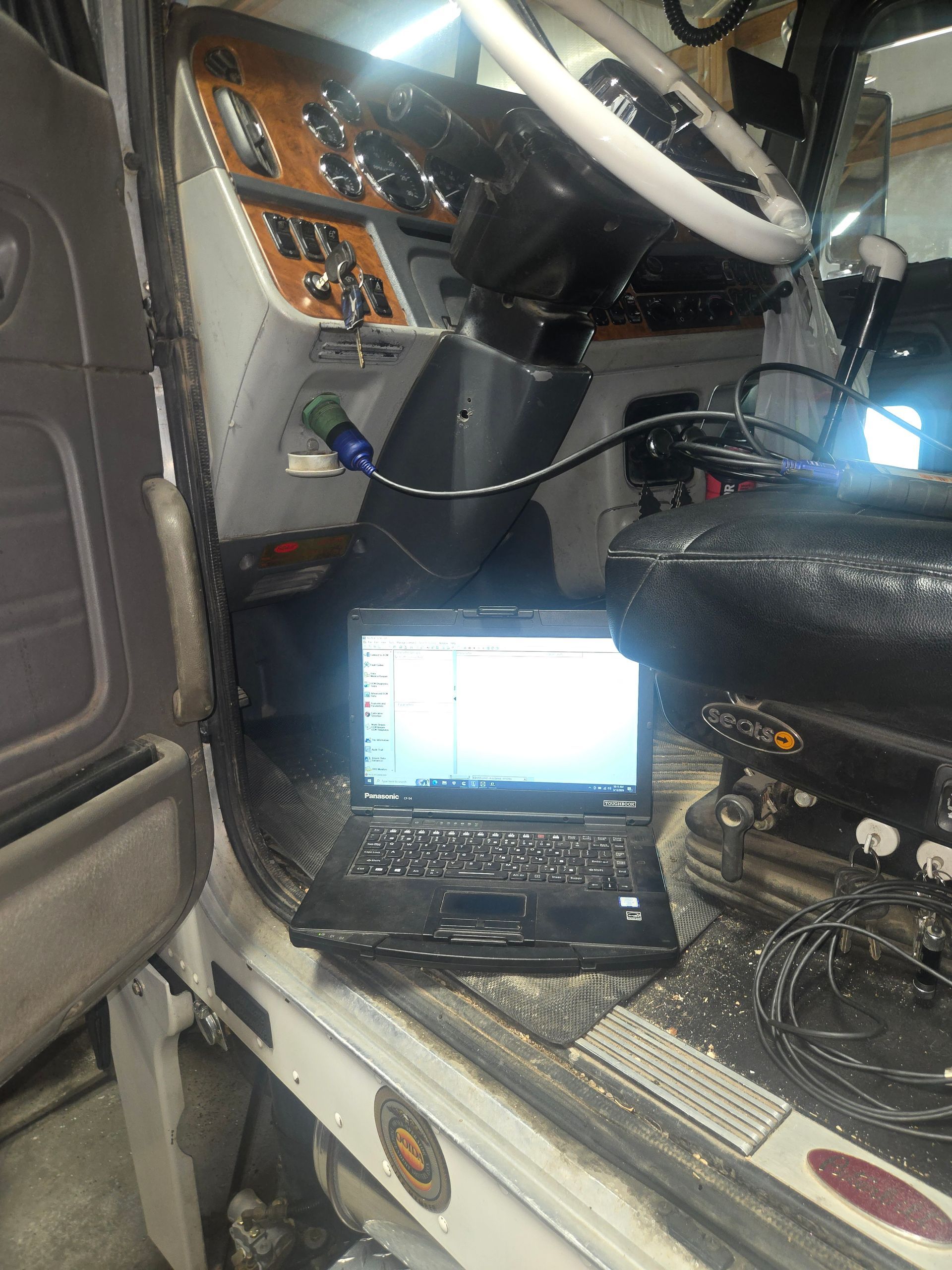 Mechanic working on a truck engine in a garage.