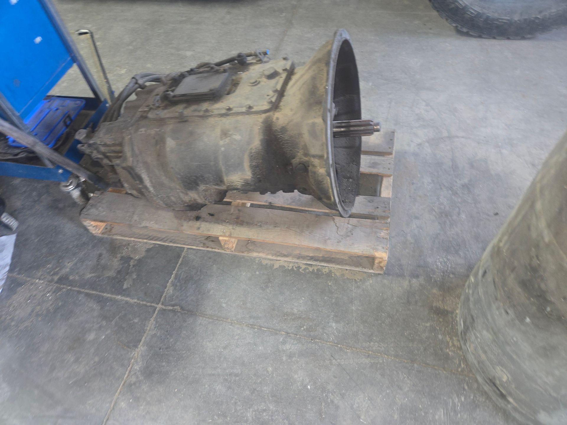 Mechanic working on an engine, using a tool. The setting is likely a repair shop.