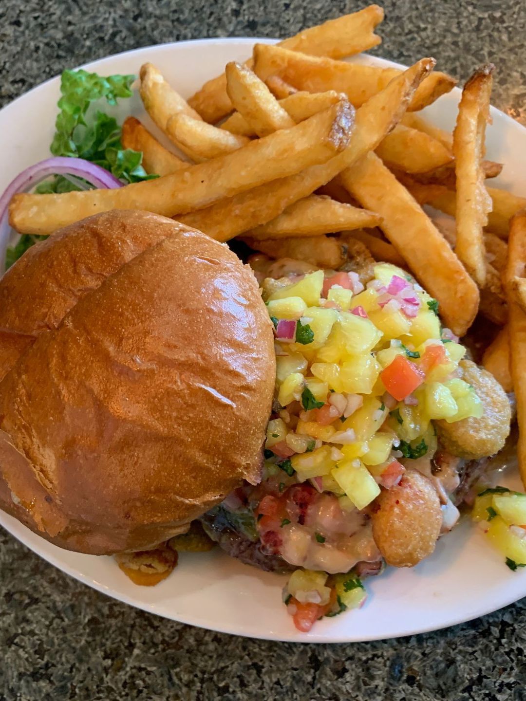 A white plate topped with a hamburger and french fries.