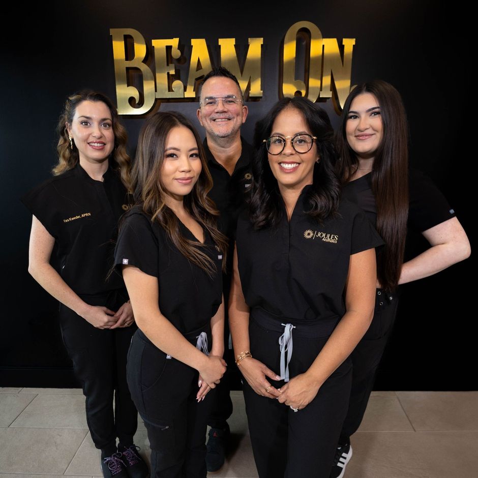 A group of people standing in front of a sign that says beam on
