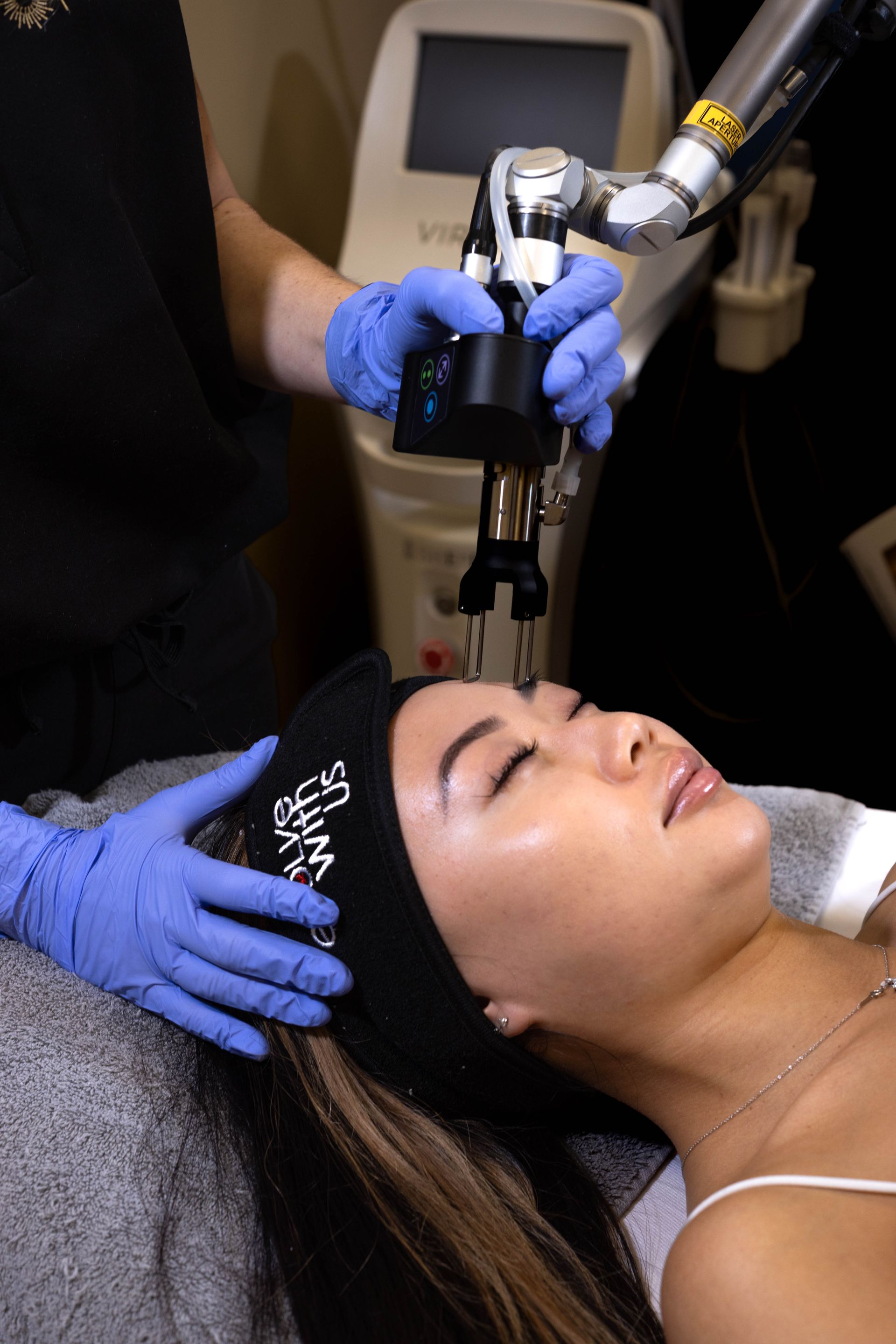 A woman is getting a laser treatment on her face.