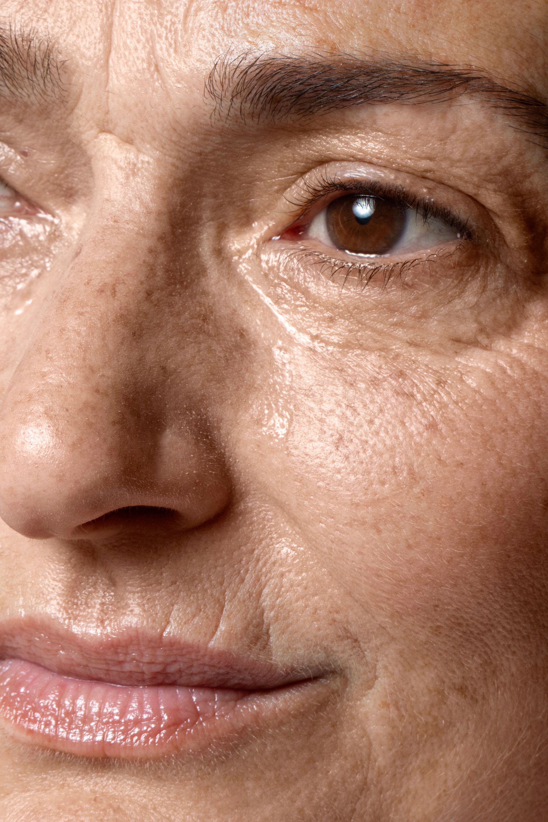 Close-up of a person's face focusing on eye and mouth areas, showing skin texture and natural skin tone.