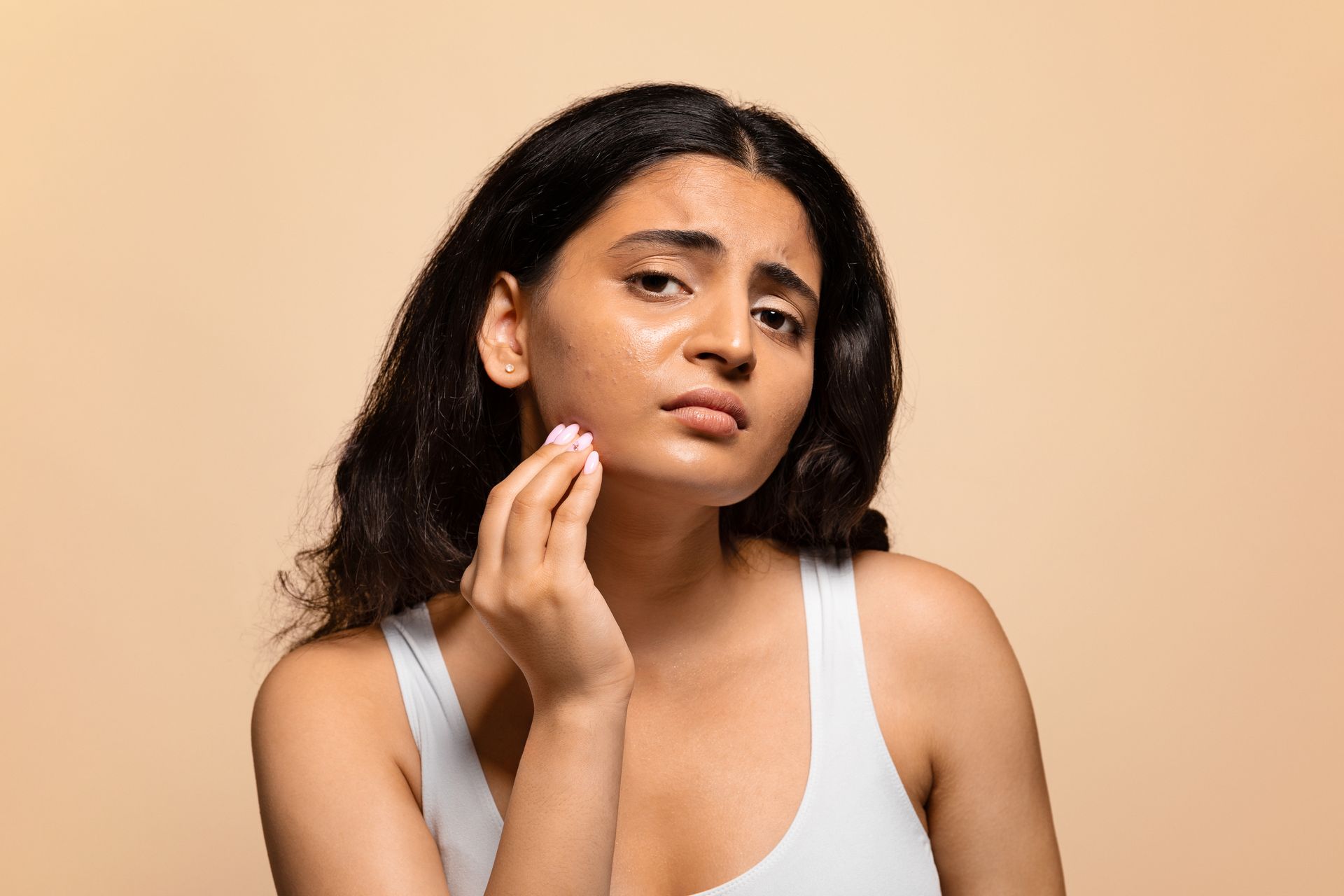 A woman is cleaning her face with a cotton swab.