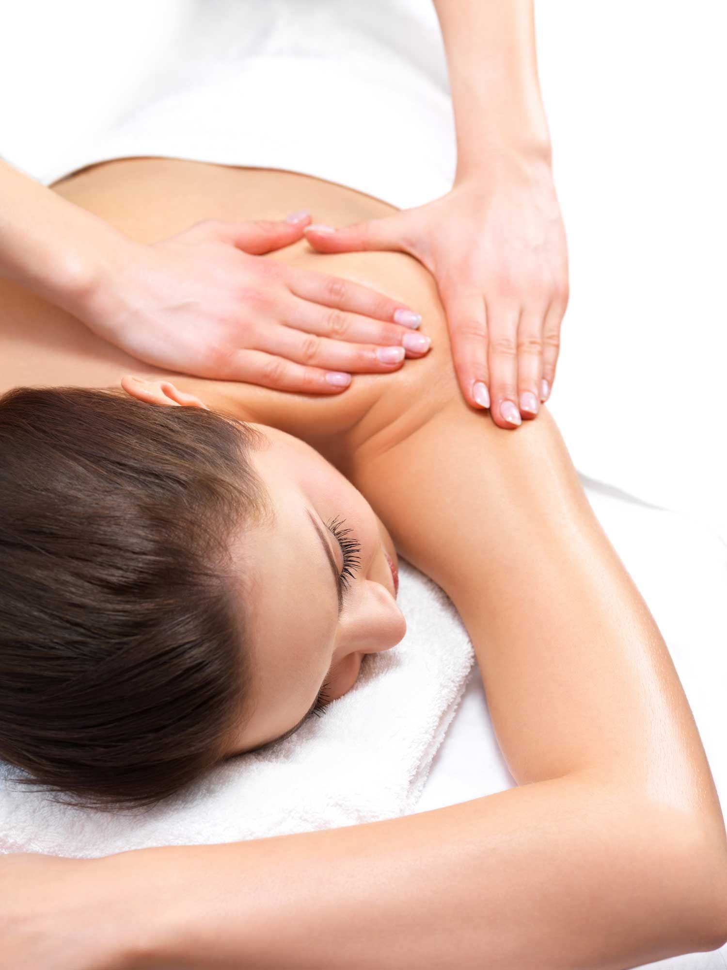 A woman is getting a massage on her back at a spa.