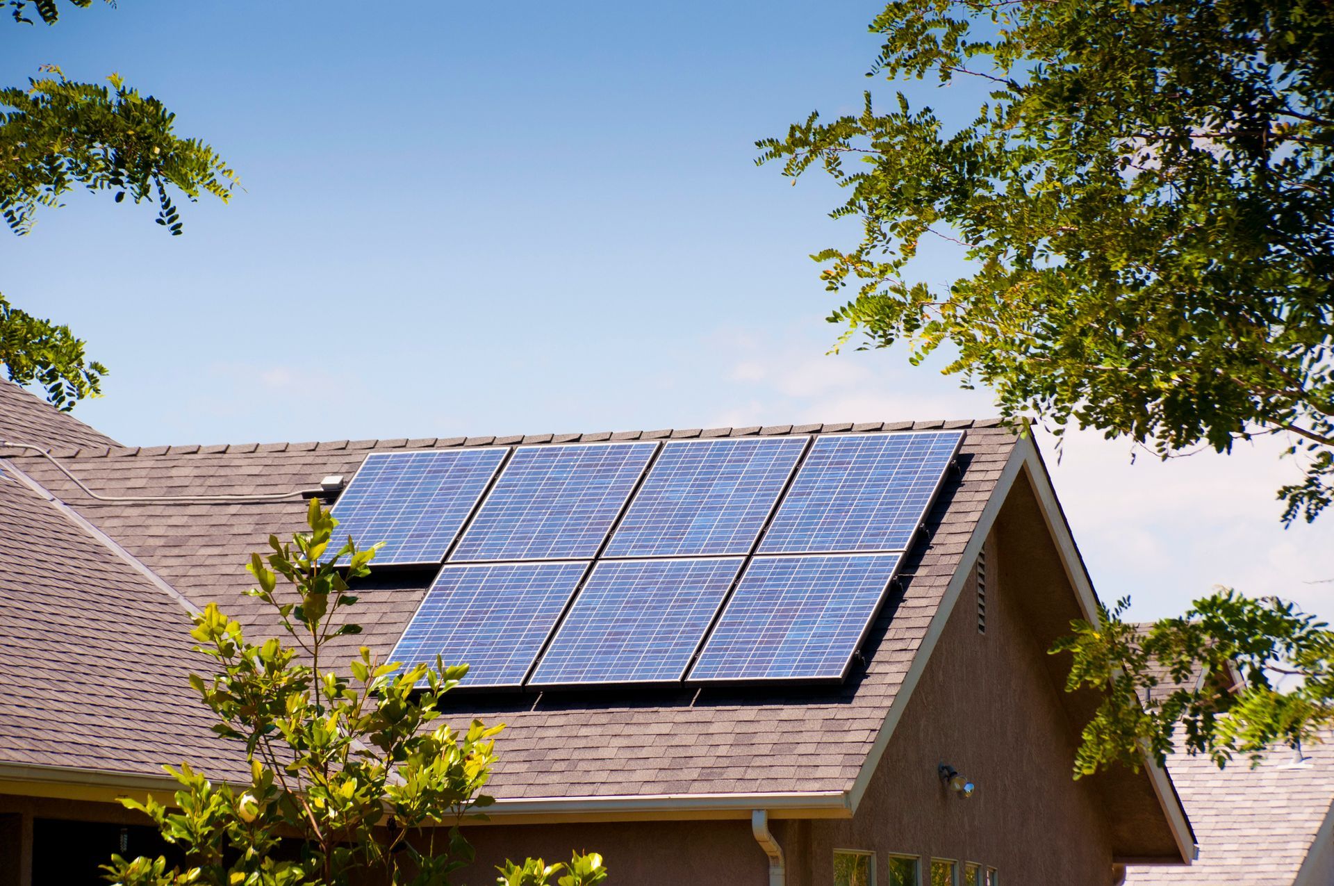 Solar panels on a residential rooftop, generating clean energy under a blue sky.