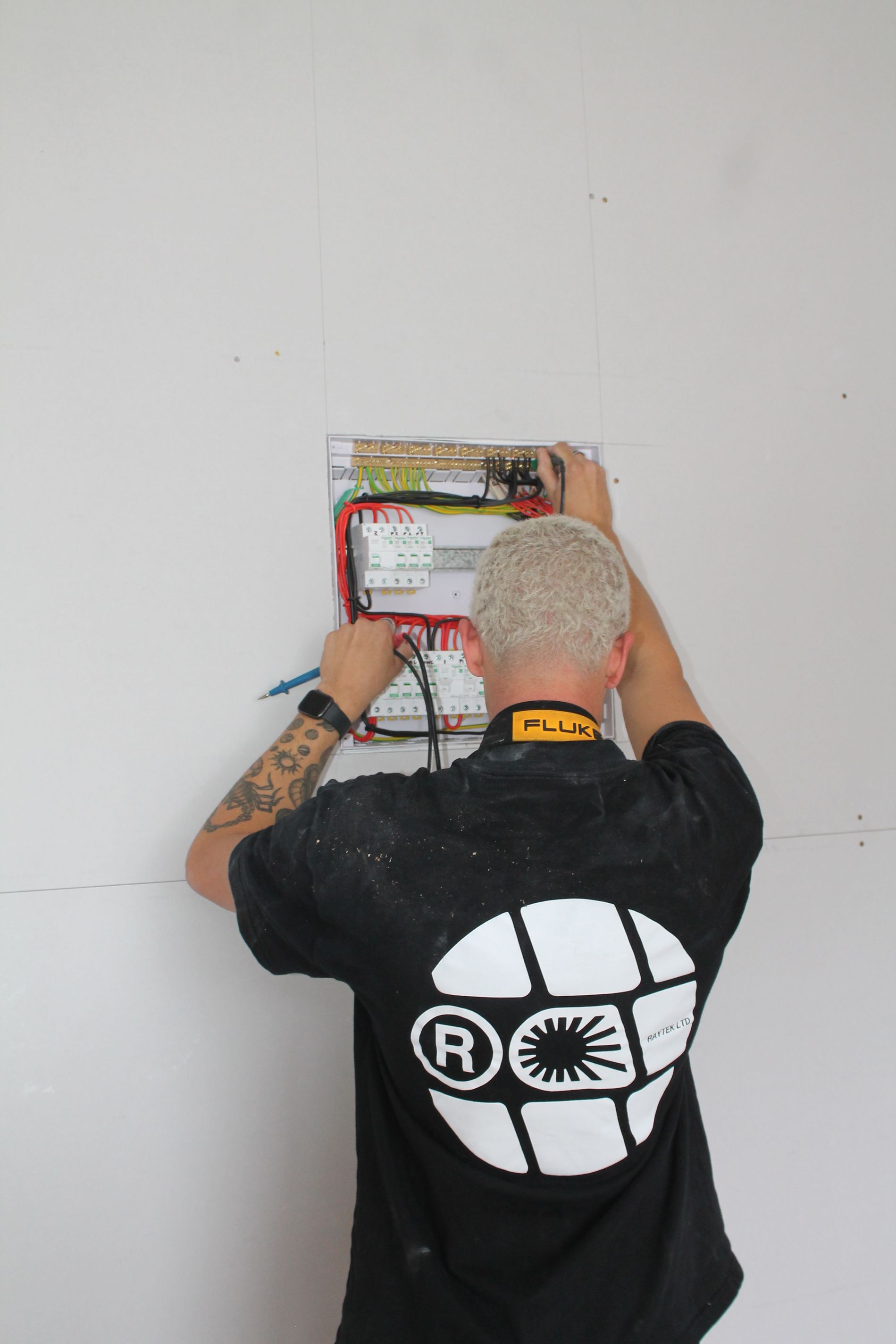 A man is holding a toolbox in a living room.