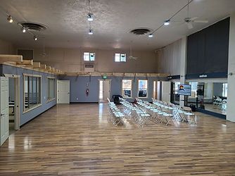 A large room with a wooden floor and chairs in it.