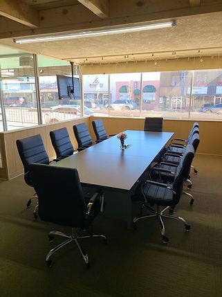 A conference room with a long table and chairs.