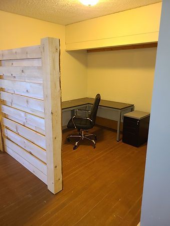 A room with a desk and a chair in it.