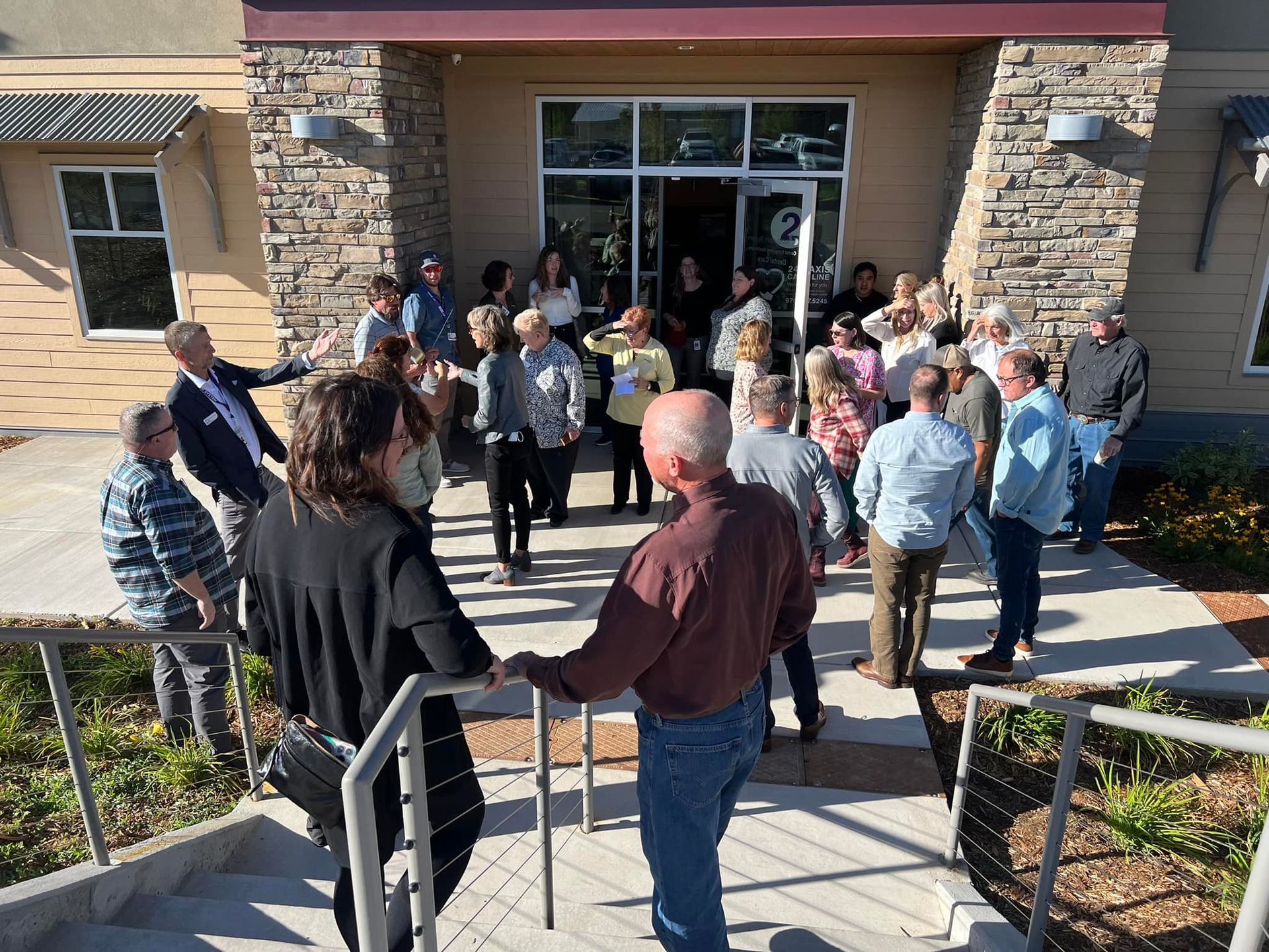 A woman is sitting in a chair in front of a glass wall.