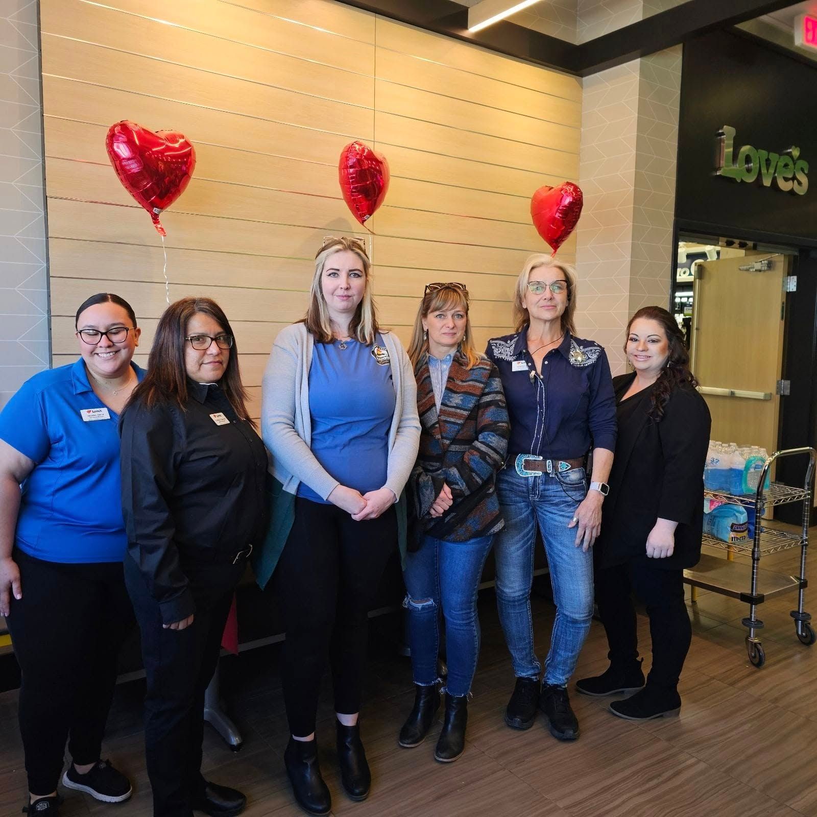 A woman in a purple dress and scarf is holding a blue folder.