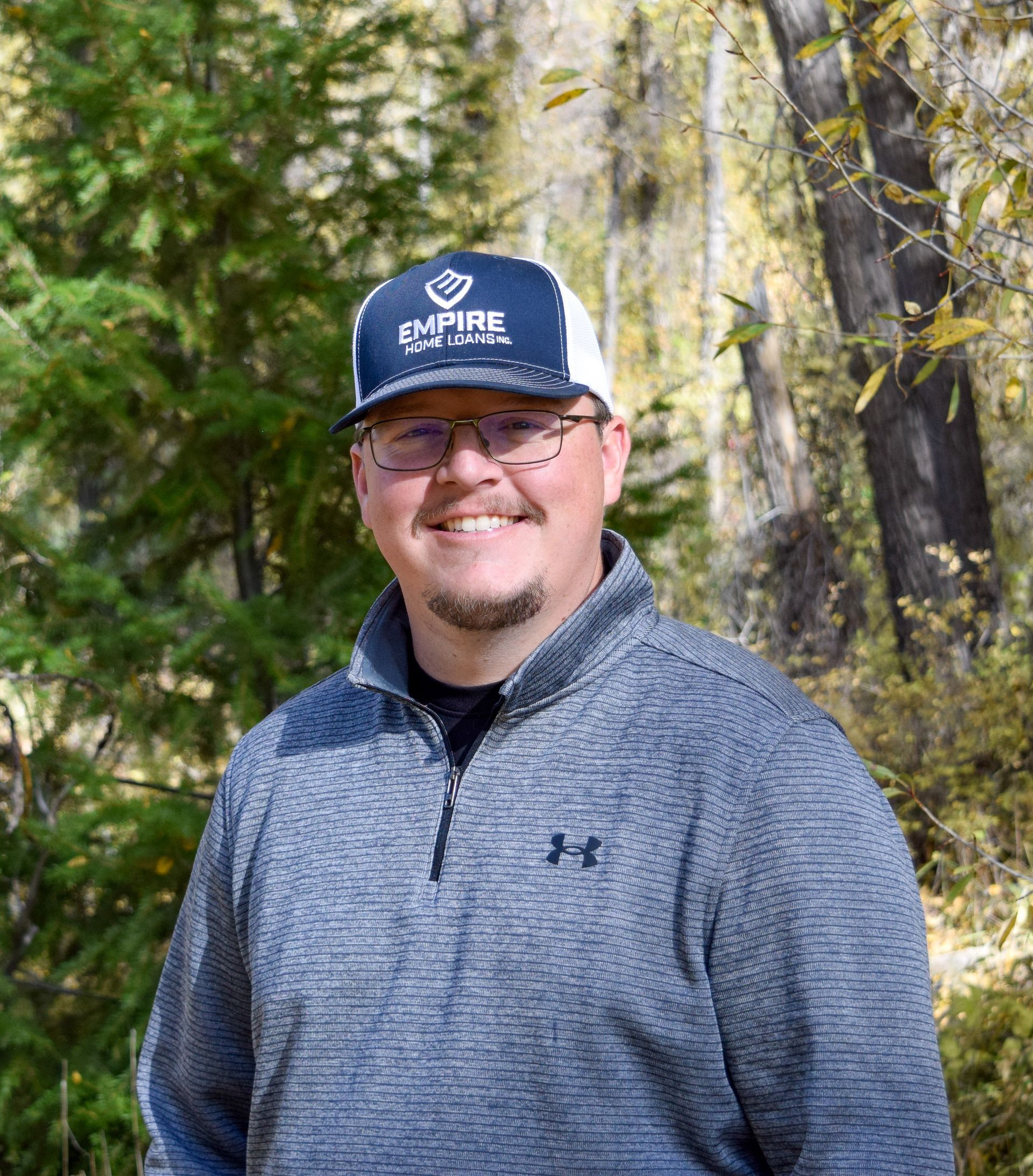 A woman wearing a necklace and earrings is standing in front of a yellow background.