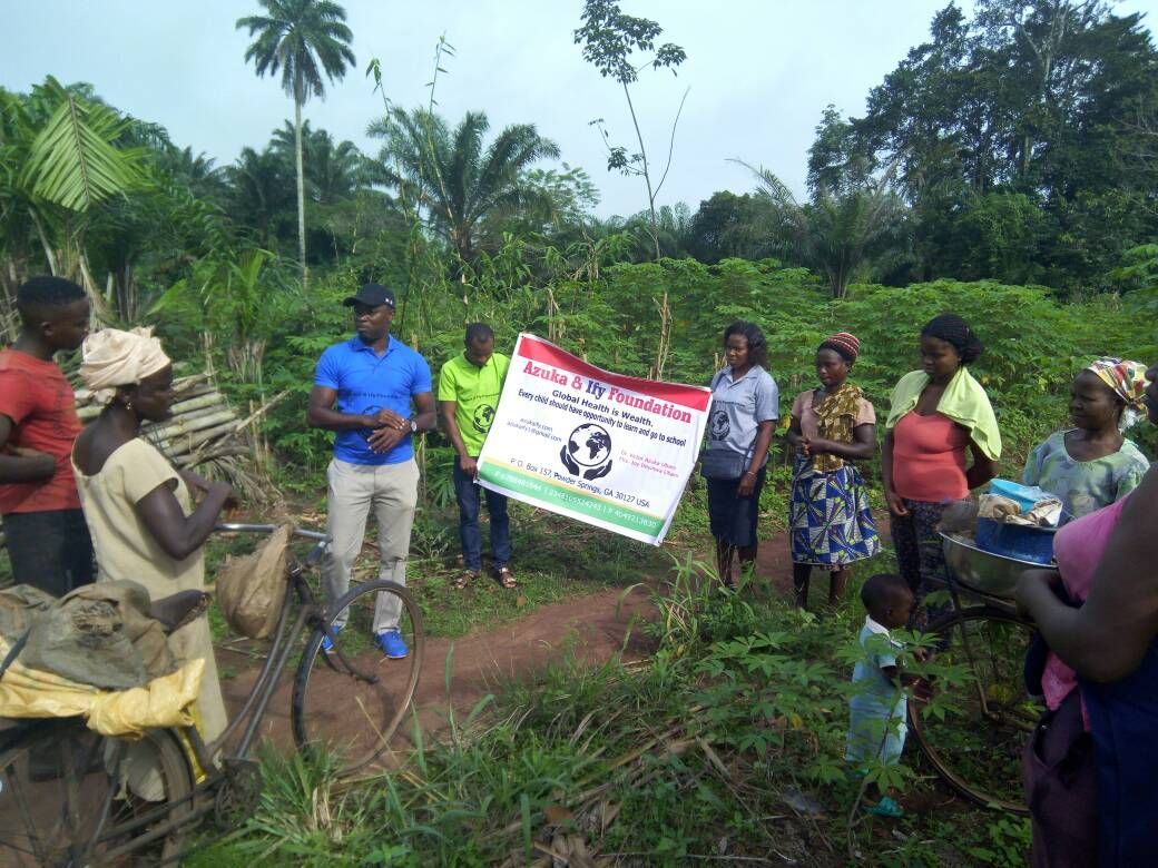 A group of people are standing in a field holding a sign.