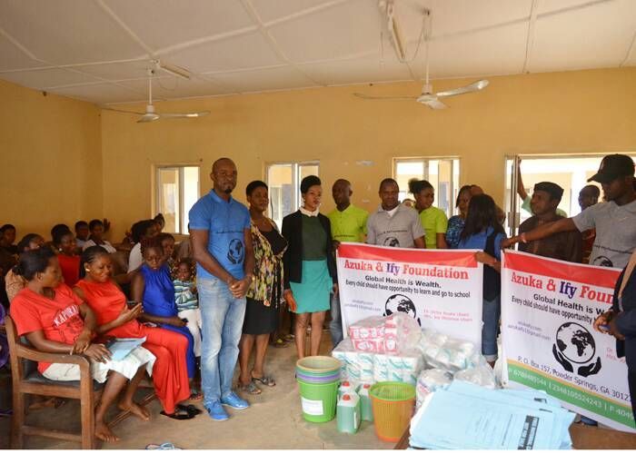 A group of people standing in a room holding signs that say make a my foundation