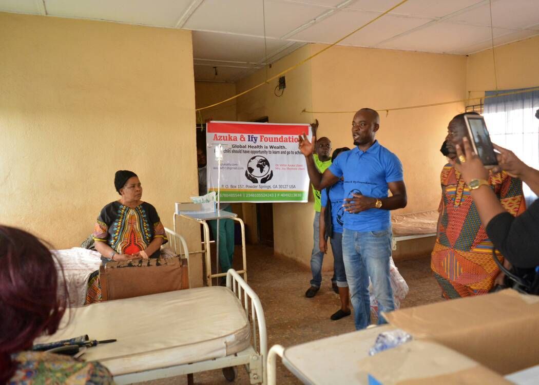 A group of people are standing around a sign in a hospital room.