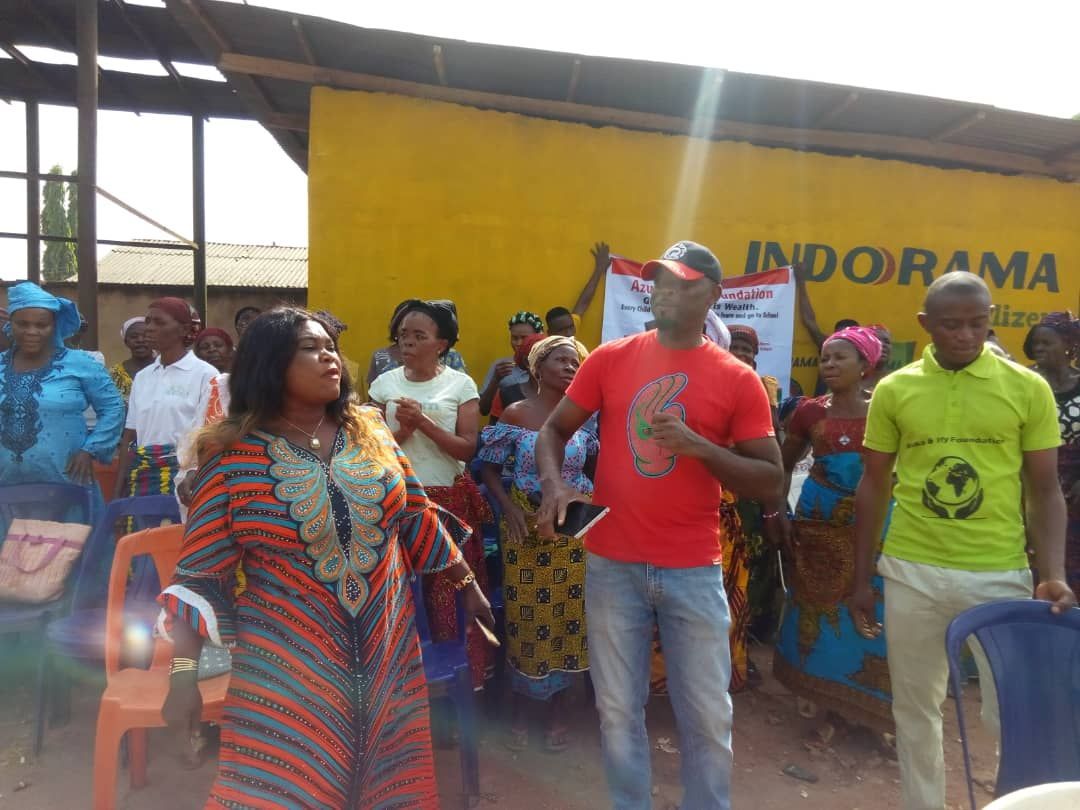 A group of people standing in front of a yellow sign that says jadora ma
